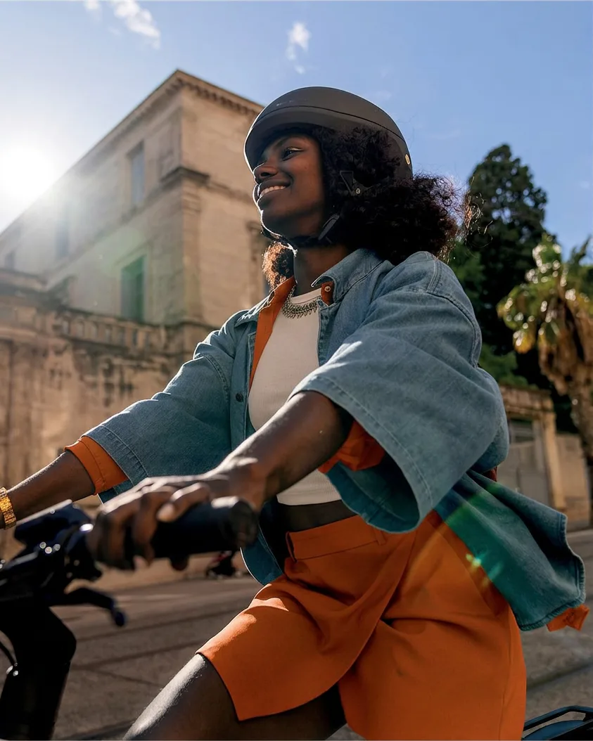 A rider in a helmet smiling on a ZestRyde bike