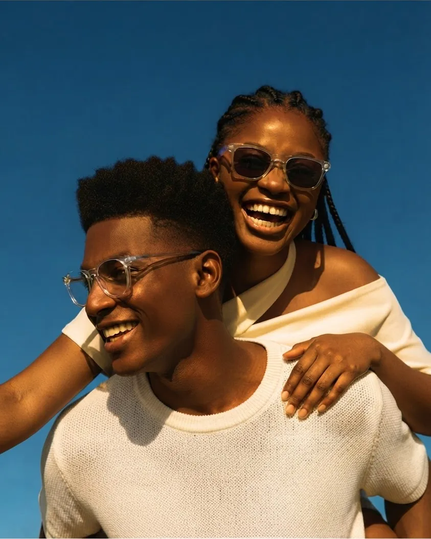 Two friends laughing together under a clear blue sky